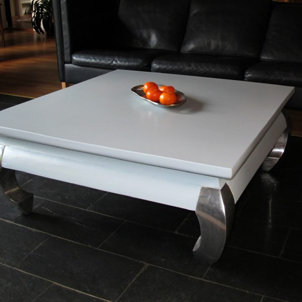 Hvidt sofabord med metal ben på sort flise bord